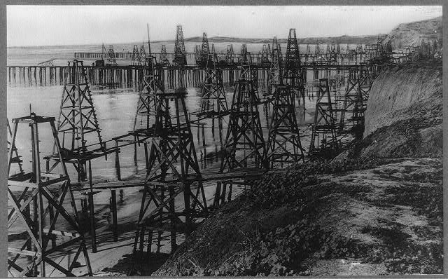 Oil derricks standing on the beach and in the surf at Summerland, California.