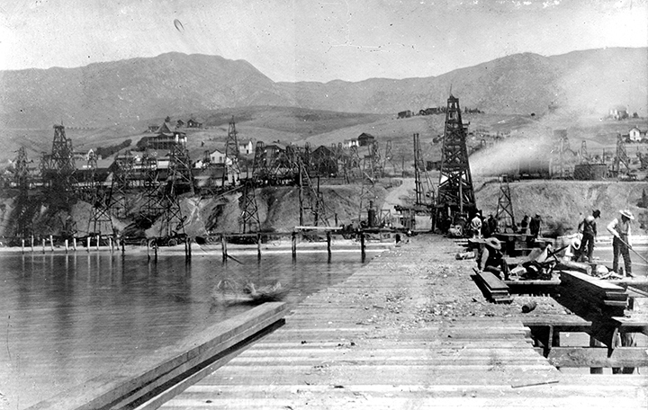 Timber oil derricks and piers along the Summerland shoreline.